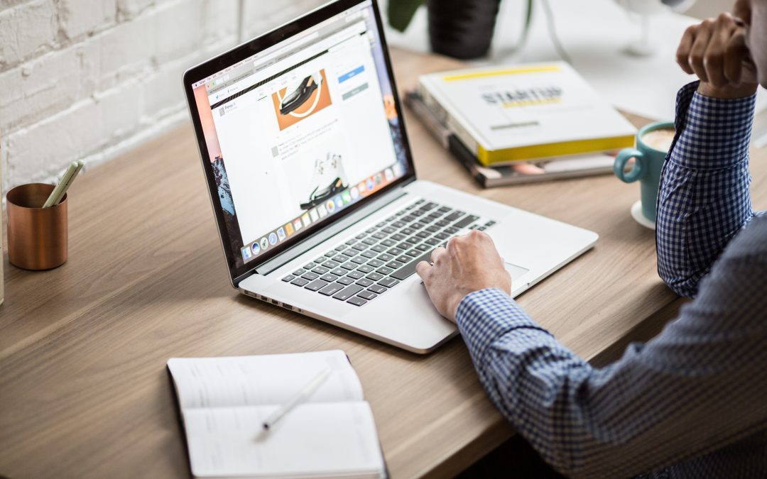 man at desk looking at laptop