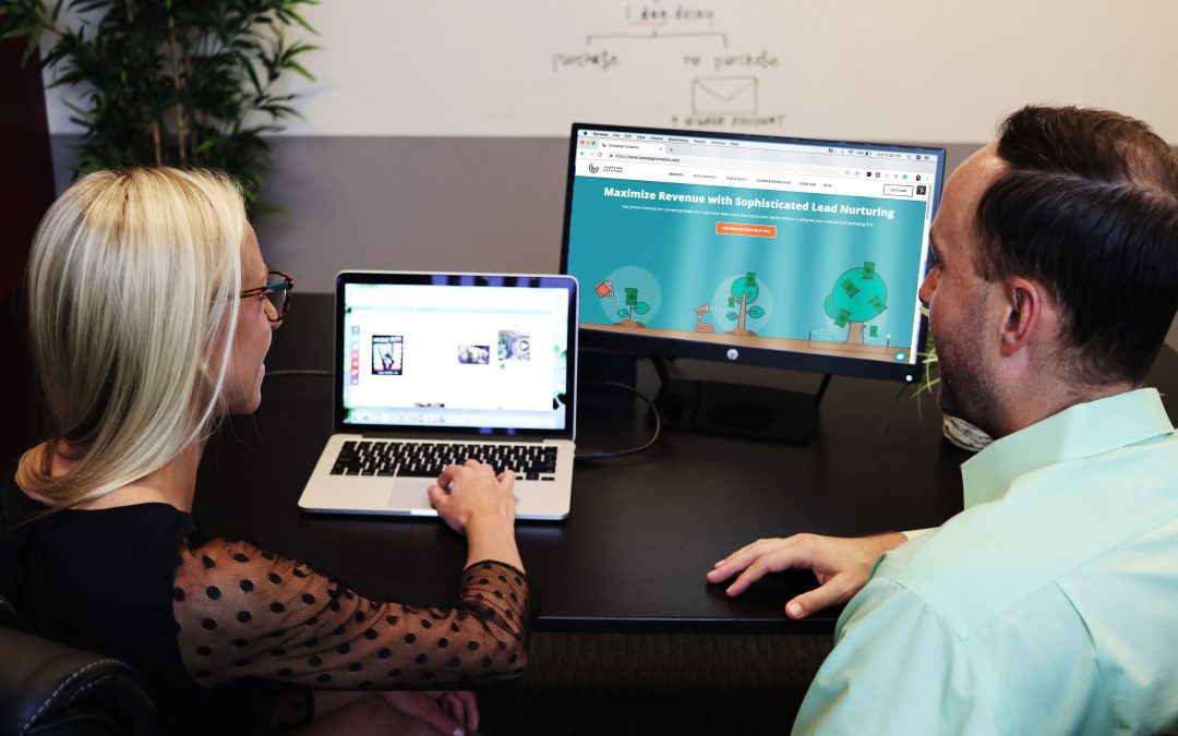 man and woman designing landing page on computers