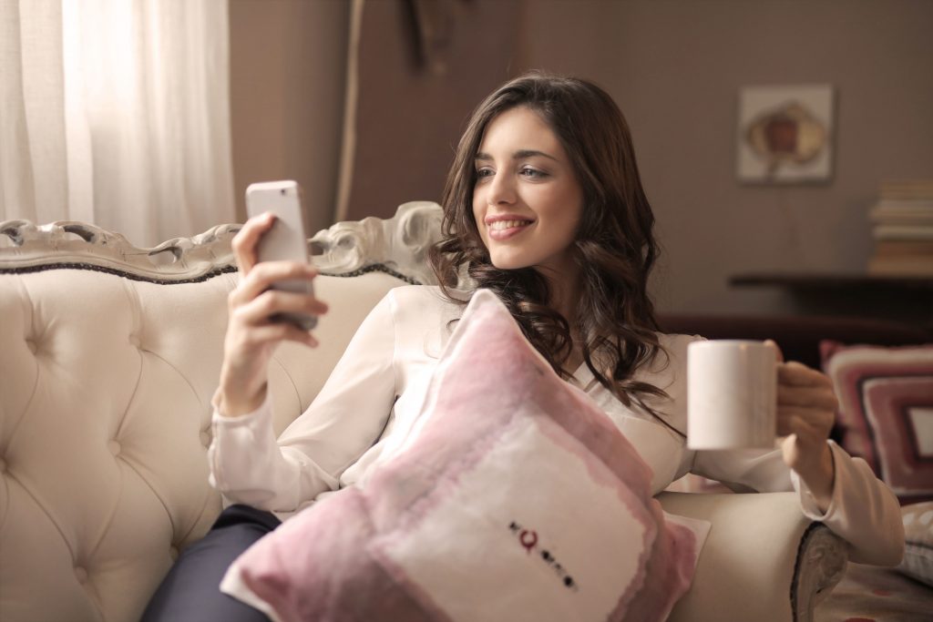 woman smiling while using phone